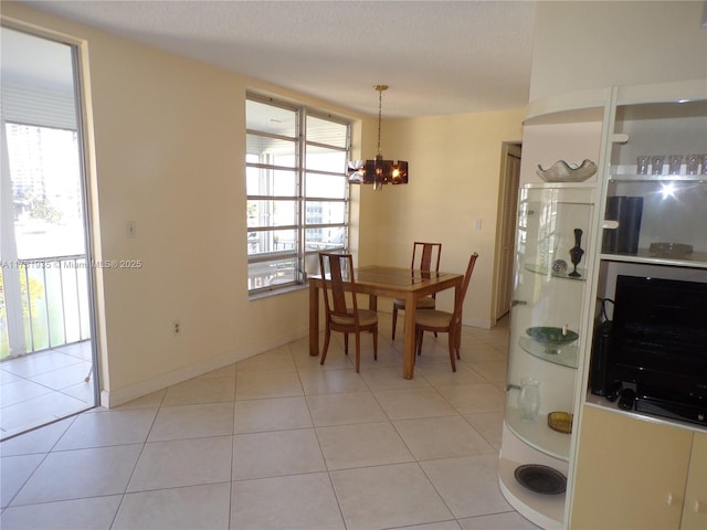 dining space with light tile patterned floors, a wealth of natural light, and a chandelier