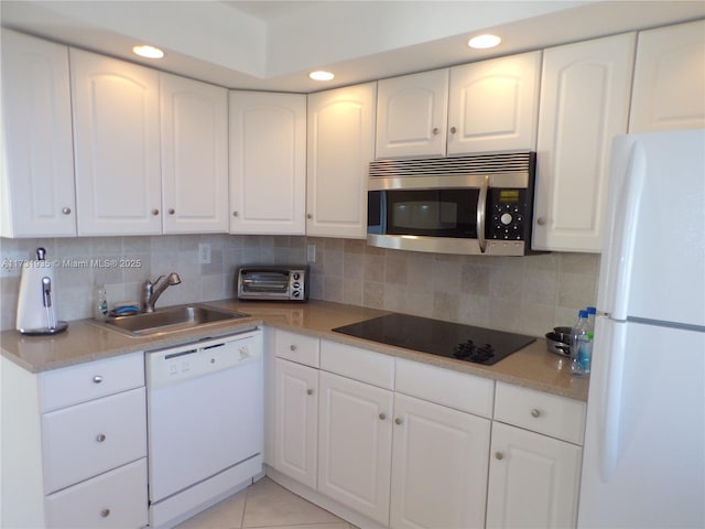 kitchen featuring white appliances, sink, decorative backsplash, and white cabinets