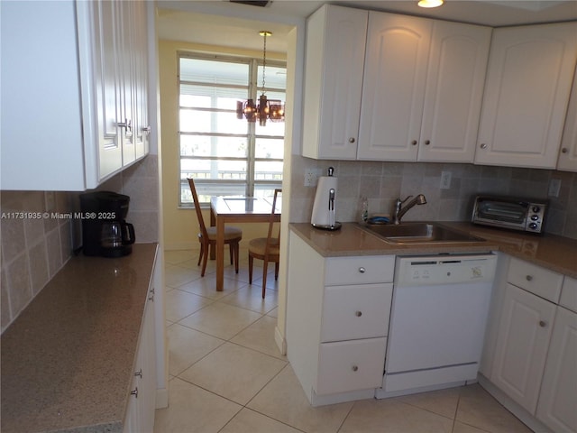 kitchen with sink, white cabinetry, light tile patterned floors, white dishwasher, and backsplash