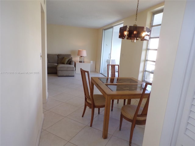 dining space with light tile patterned floors and a notable chandelier