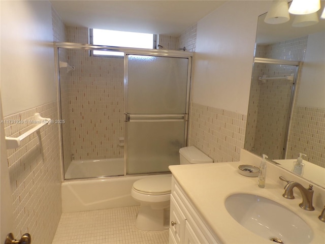 full bathroom featuring tile walls, tile patterned flooring, shower / bath combination with glass door, and toilet