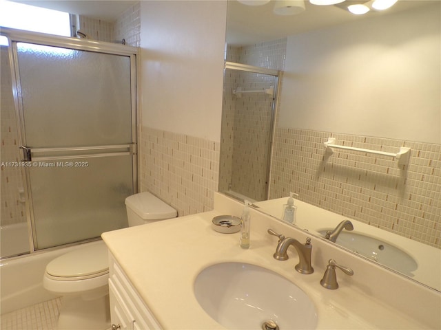 full bathroom with enclosed tub / shower combo, tile walls, tile patterned flooring, vanity, and toilet