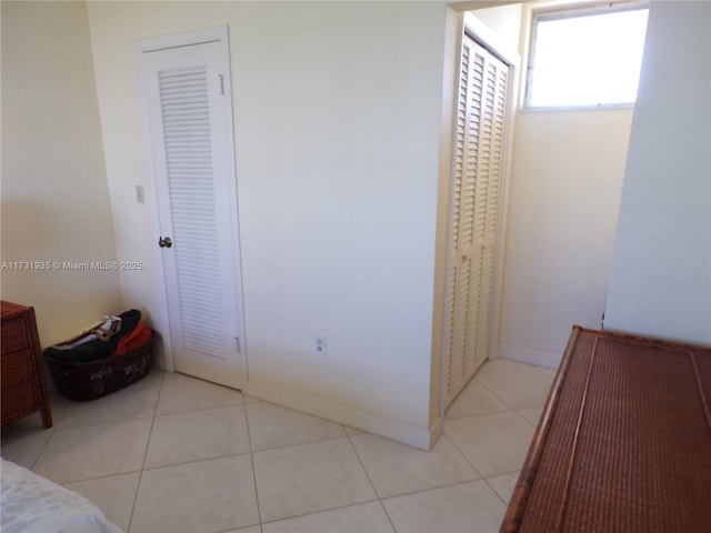 unfurnished bedroom featuring light tile patterned floors and a closet