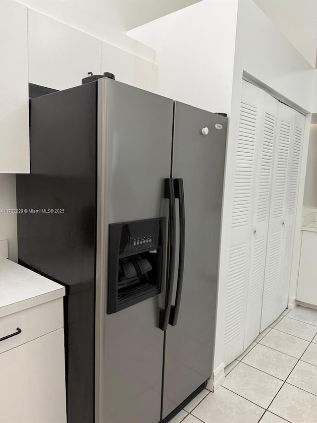 kitchen featuring light tile patterned flooring, white cabinets, and stainless steel fridge with ice dispenser