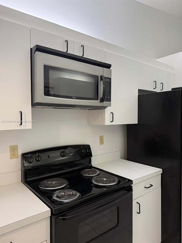 kitchen featuring white cabinets, a textured ceiling, and black appliances