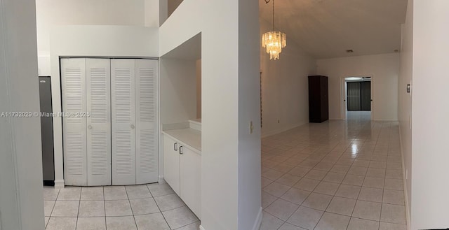 hallway featuring light tile patterned floors and a notable chandelier