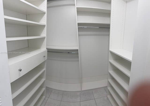 spacious closet with light tile patterned floors