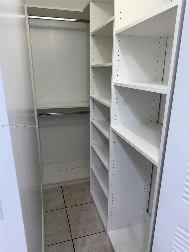 walk in closet with light tile patterned floors