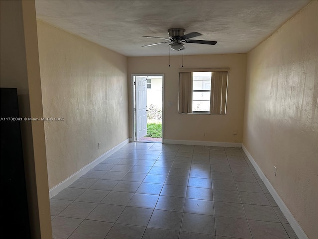 tiled spare room with ceiling fan