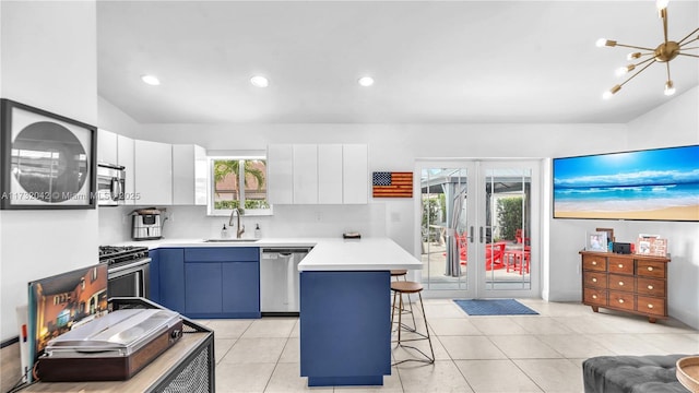 kitchen with sink, a breakfast bar, white cabinetry, stainless steel appliances, and french doors