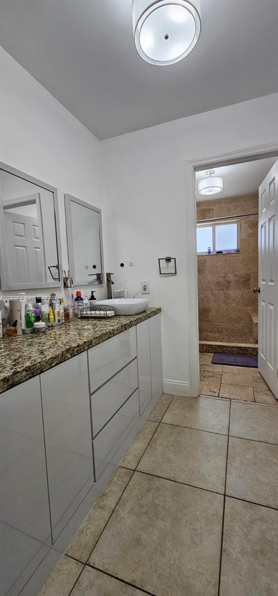 bathroom featuring vanity and tiled shower