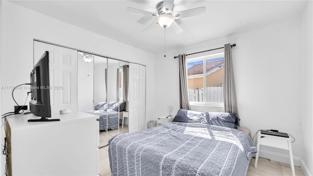 tiled bedroom featuring ceiling fan and a closet