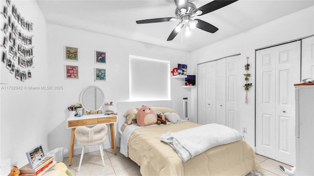 bedroom featuring multiple closets, light tile patterned floors, and ceiling fan