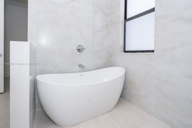 bathroom with a bathing tub and tile walls