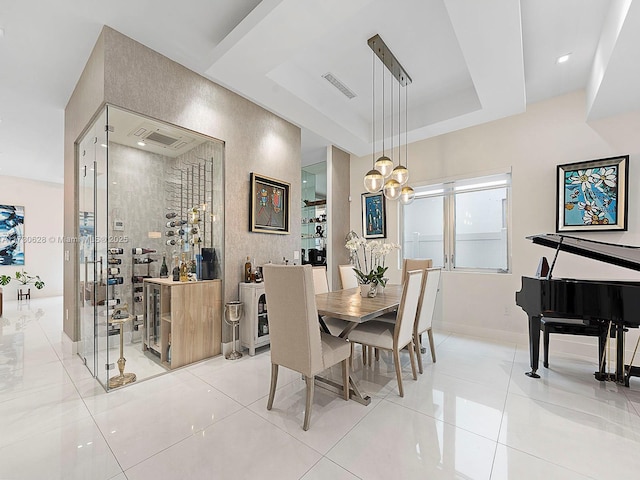 dining area featuring light tile patterned floors and a raised ceiling