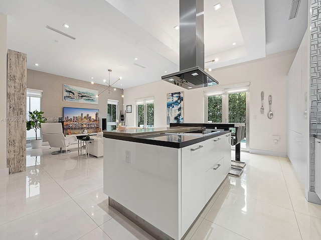 kitchen featuring island exhaust hood, a wealth of natural light, white cabinets, and a spacious island