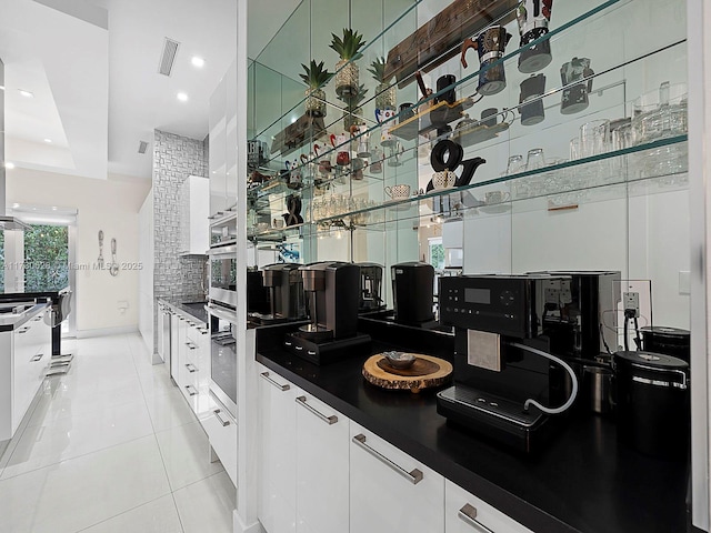 kitchen featuring white cabinetry, light tile patterned floors, and tasteful backsplash