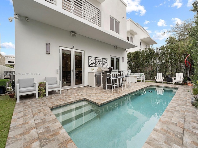 view of pool with an outdoor bar and a patio area