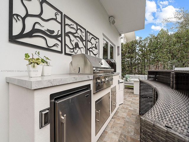 view of patio with an outdoor living space, grilling area, and exterior kitchen