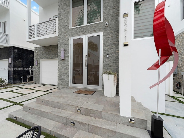 property entrance featuring a garage and french doors