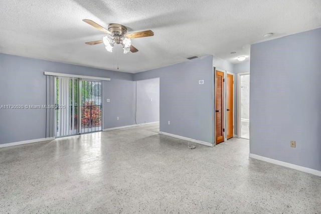 unfurnished room with ceiling fan and a textured ceiling