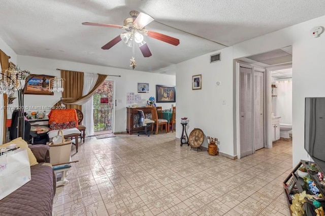 living room with ceiling fan and a textured ceiling