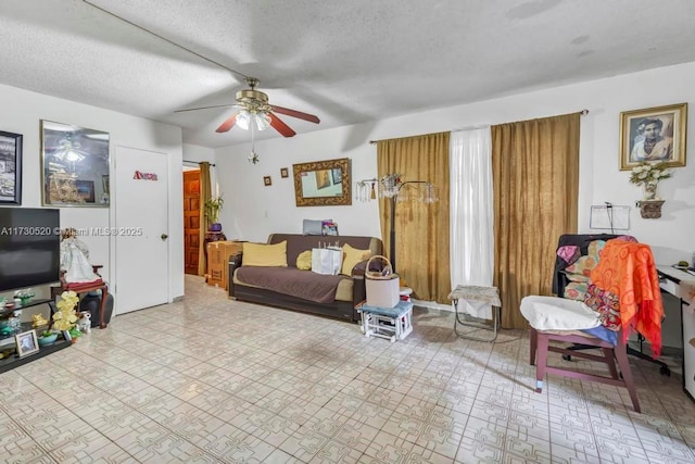 living room with ceiling fan and a textured ceiling