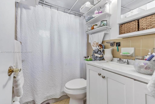 bathroom with tile patterned flooring, backsplash, vanity, and toilet