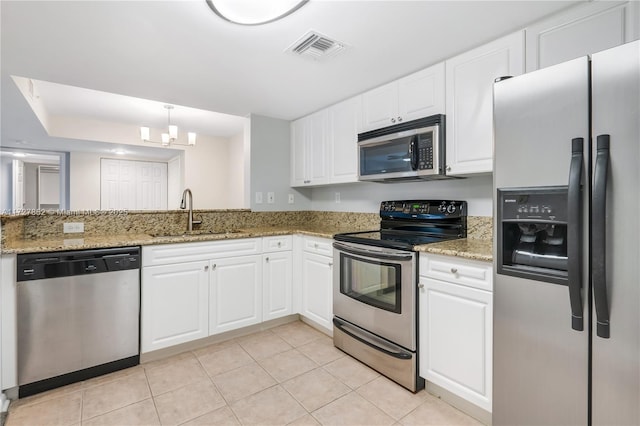 kitchen featuring sink, light stone counters, light tile patterned floors, stainless steel appliances, and white cabinets