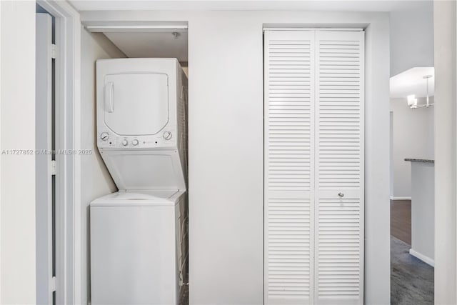 washroom featuring hardwood / wood-style flooring and stacked washing maching and dryer