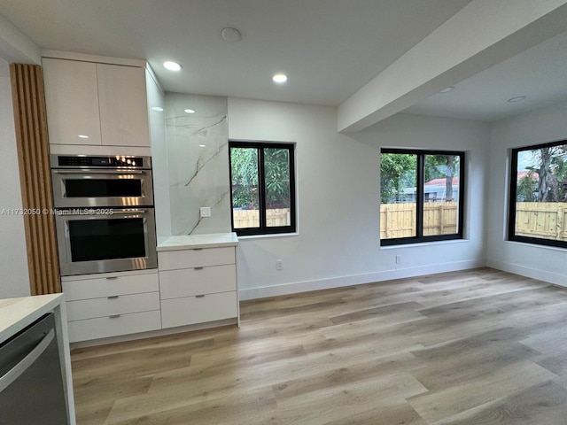 kitchen with white cabinetry, appliances with stainless steel finishes, and light hardwood / wood-style floors