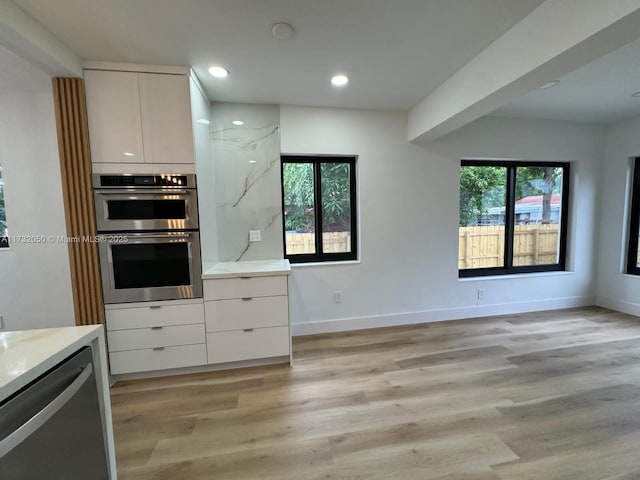 kitchen featuring white cabinetry, appliances with stainless steel finishes, and light hardwood / wood-style flooring