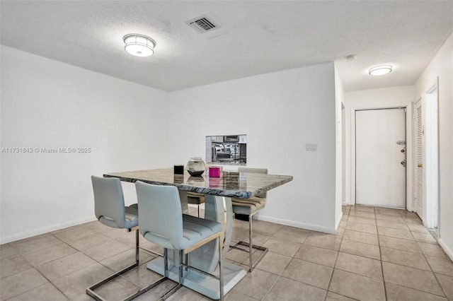 dining room featuring light tile patterned floors and a textured ceiling