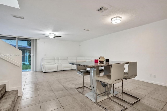 dining room featuring light tile patterned floors, a textured ceiling, and ceiling fan