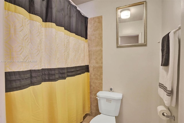 bathroom with a shower with curtain and toilet