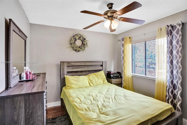 bedroom with a textured ceiling, dark hardwood / wood-style floors, and ceiling fan