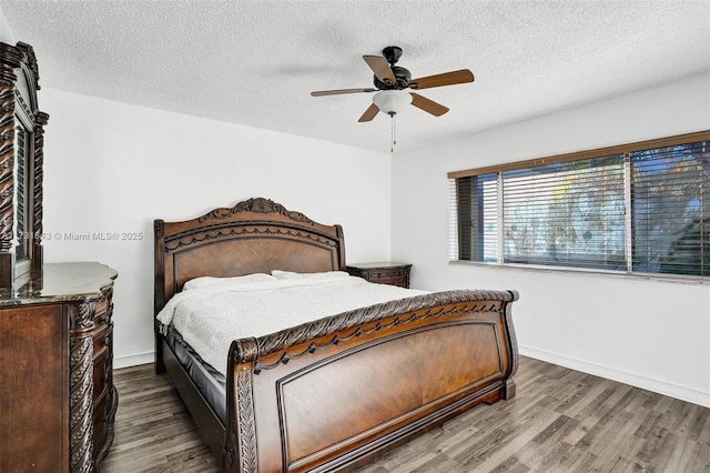 bedroom with a textured ceiling, ceiling fan, and hardwood / wood-style flooring