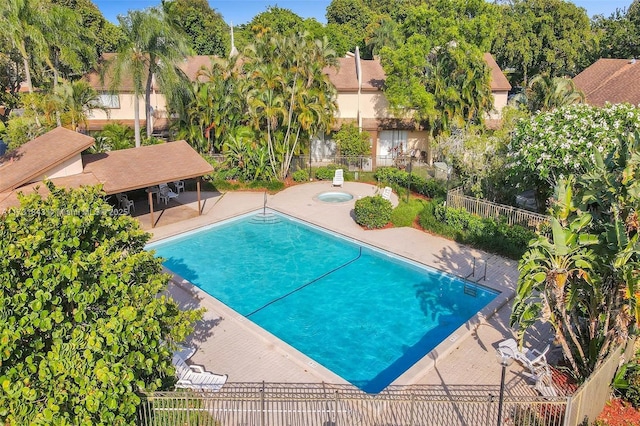 view of swimming pool featuring a hot tub and a patio