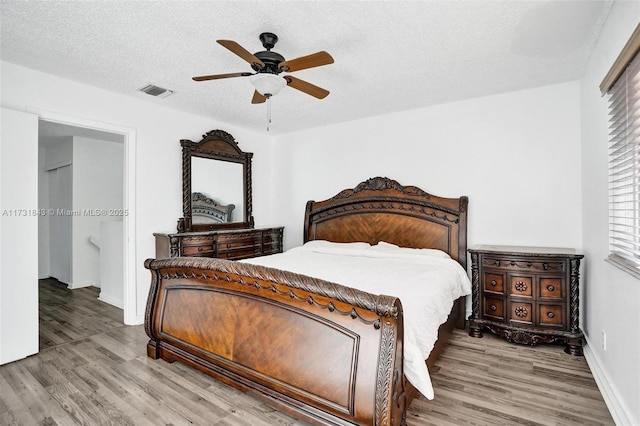 bedroom featuring wood-type flooring, a textured ceiling, and ceiling fan