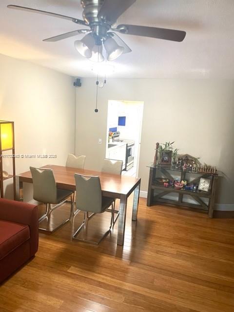 dining area featuring wood-type flooring and ceiling fan