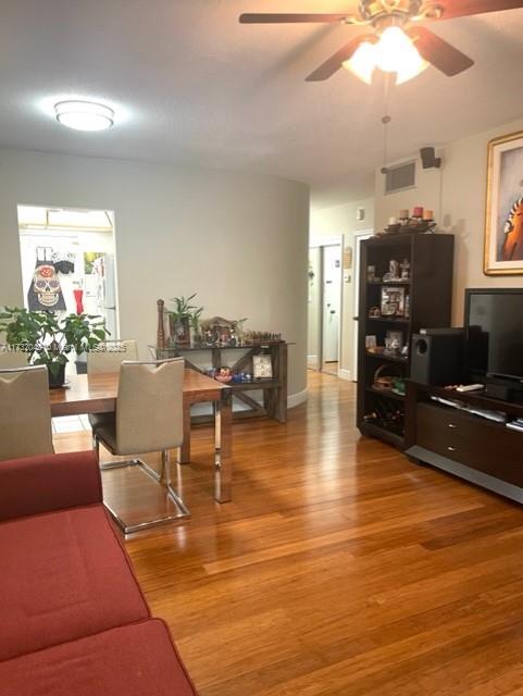 living room with ceiling fan and wood-type flooring