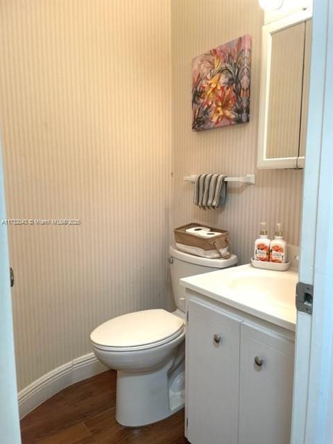 bathroom with vanity, wood-type flooring, and toilet