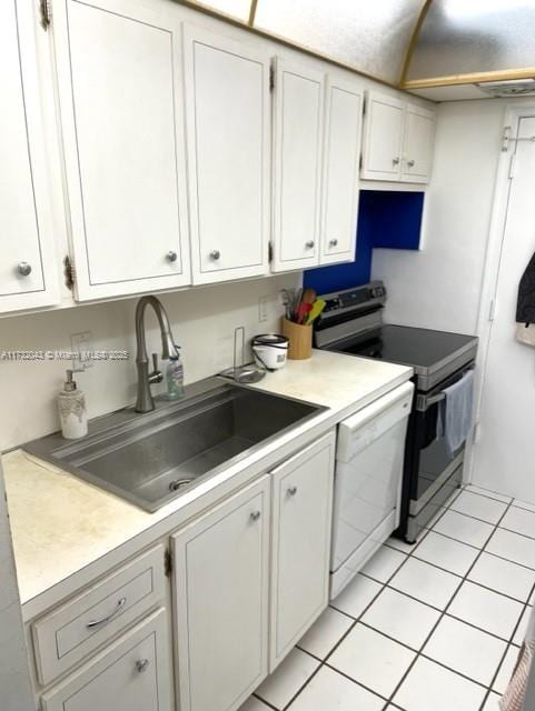 kitchen featuring sink, stainless steel range with electric stovetop, white dishwasher, white cabinets, and light tile patterned flooring