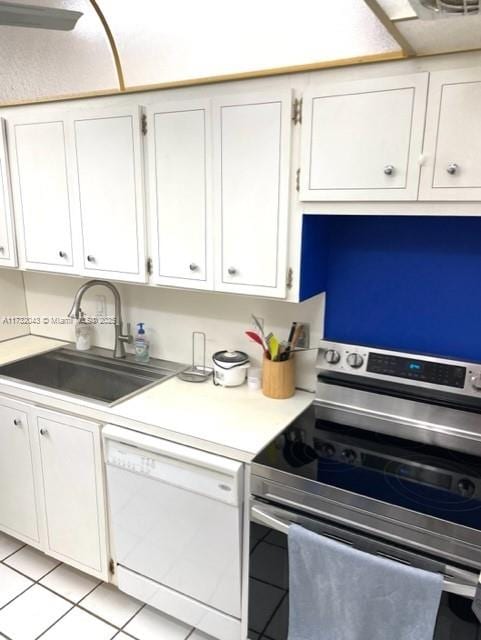 kitchen with white dishwasher, sink, white cabinetry, and stainless steel range with electric cooktop