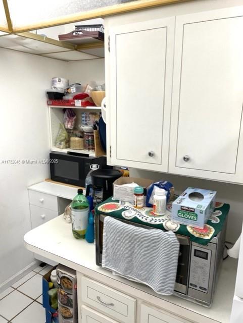 clothes washing area with light tile patterned floors