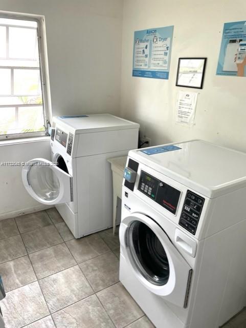 laundry room featuring light tile patterned flooring and separate washer and dryer