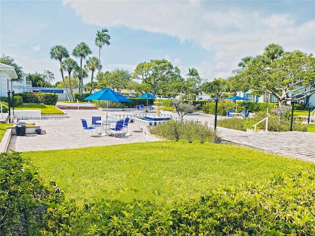 view of property's community featuring a patio and a lawn