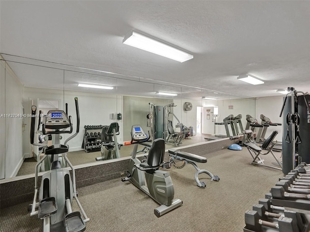 exercise room with carpet flooring and a textured ceiling