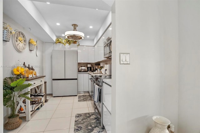 kitchen with white cabinetry, stainless steel appliances, and light tile patterned flooring