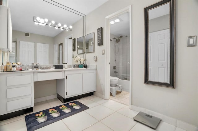 full bathroom featuring tile patterned flooring, vanity, bath / shower combo with glass door, and toilet